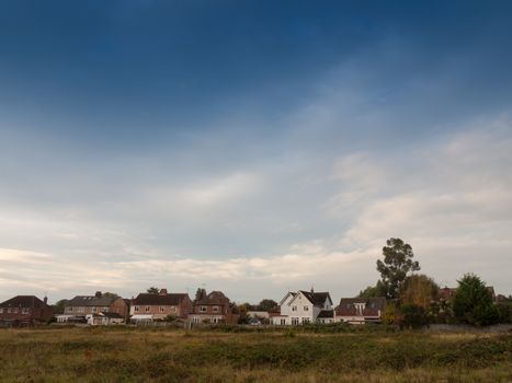 row of country houses with blue sky above horizon; essex; england; uk