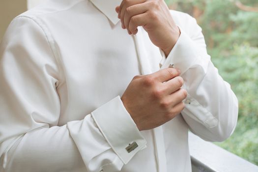 man buttons shirt, a man in a white shirt, morning groom, hands of a man close-up, a white shirt on a businessman, man buttons shirt sleeve, businessman puts on a suit