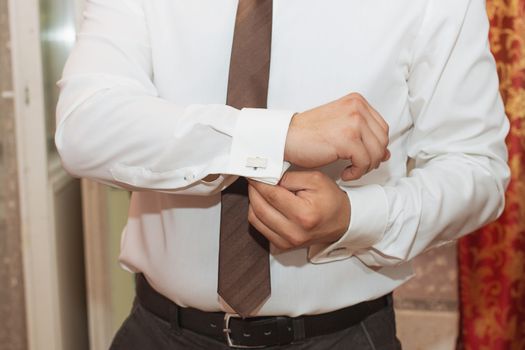 man buttons shirt, a man in a white shirt, morning groom, hands of a man close-up, a white shirt on a businessman, man buttons shirt sleeve, businessman puts on a suit