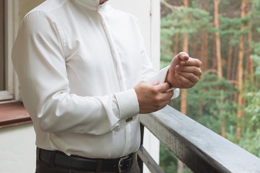 man buttons shirt, a man in a white shirt, morning groom, hands of a man close-up, a white shirt on a businessman, man buttons shirt sleeve, businessman puts on a suit