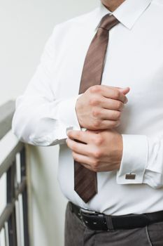 man buttons shirt, a man in a white shirt, morning groom, hands of a man close-up, a white shirt on a businessman, man buttons shirt sleeve, businessman puts on a suit
