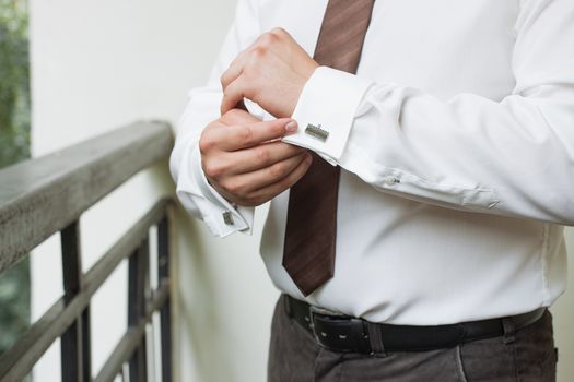 man buttons shirt, a man in a white shirt, morning groom, hands of a man close-up, a white shirt on a businessman, man buttons shirt sleeve, businessman puts on a suit