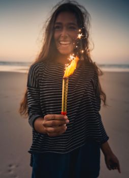 Teenage girl on the beach holding Fireworks 