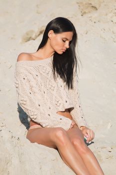 Sensual beautiful brunette woman posing on the beach at night.