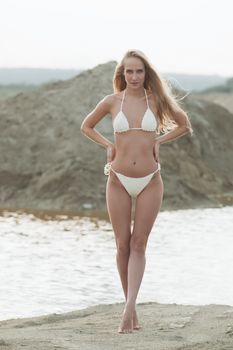 Girl on the sandy beach in a bathing suit.