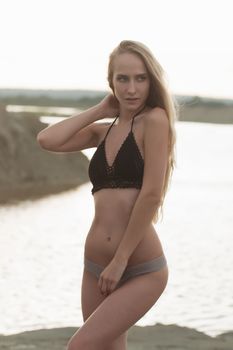 Girl on the sandy beach in a bathing suit.