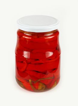 Close up of one glass jar of pickled red hot cherry chili pepperoncini peppers over white background, high angle view
