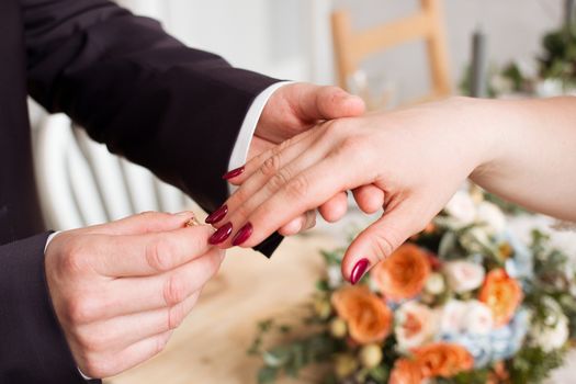 wedding rings and hands of bride and groom. young wedding couple at ceremony. matrimony. man and woman in love. two happy people celebrating becoming family.