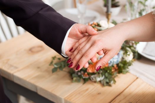 wedding rings and hands of bride and groom. young wedding couple at ceremony. matrimony. man and woman in love. two happy people celebrating becoming family.