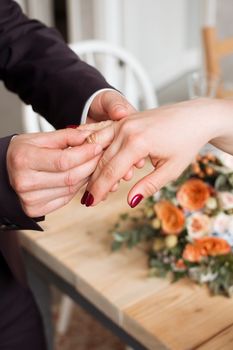 wedding rings and hands of bride and groom. young wedding couple at ceremony. matrimony. man and woman in love. two happy people celebrating becoming family.