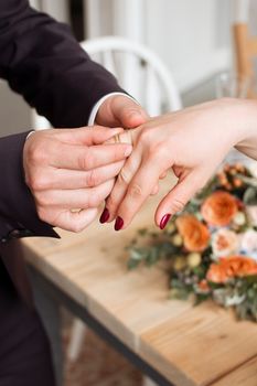 wedding rings and hands of bride and groom. young wedding couple at ceremony. matrimony. man and woman in love. two happy people celebrating becoming family.