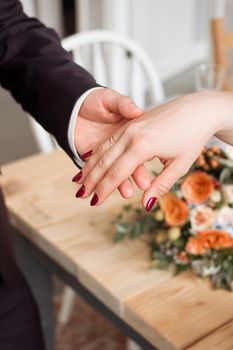 wedding rings and hands of bride and groom. young wedding couple at ceremony. matrimony. man and woman in love. two happy people celebrating becoming family.