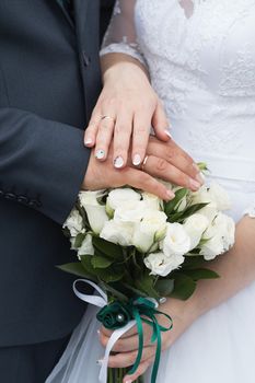 wedding rings and hands of bride and groom. young wedding couple at ceremony. matrimony. man and woman in love. two happy people celebrating becoming family.