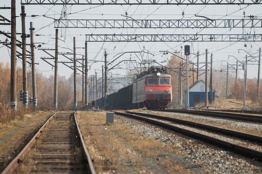 Freight train locomotive carrying with cargo on daylight.