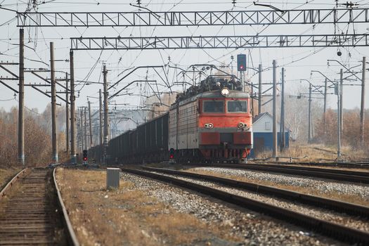 Freight train locomotive carrying with cargo on daylight.