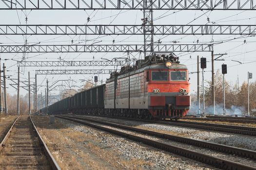 Freight train locomotive carrying with cargo on daylight.