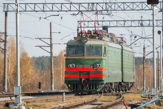 Freight train locomotive carrying with cargo on daylight.