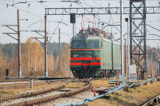 Freight train locomotive carrying with cargo on daylight.