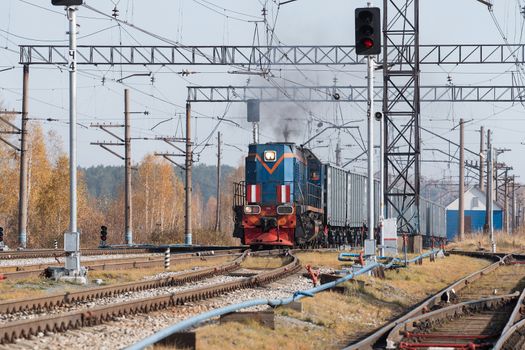 Freight train locomotive carrying with cargo on daylight.