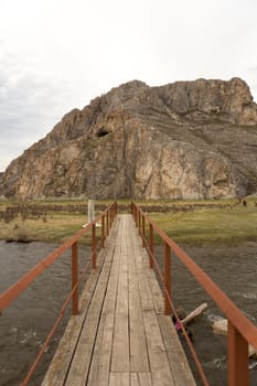 The old hanging footbridge across a small river.