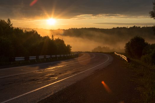 The curve of the road in the mountains. Sunset