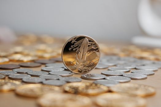 Digital currency physical metal gold feather coin with red heart. Cryptocurrency concept.
