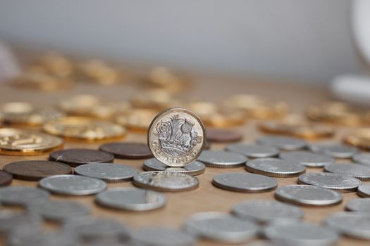 One silver and gold british pound coin. Cash from United Kingdom.