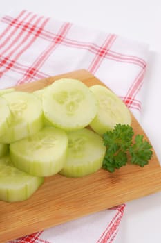 pile of sliced cucumber on wooden cutting board