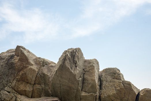 Huge stone mountain on sky background with clouds