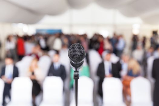Microphone in focus against blurred audience. Participants at the business or professional conference.