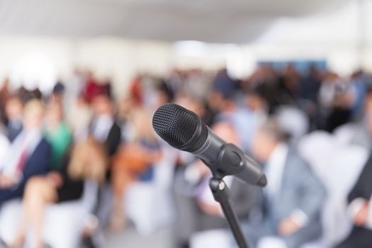 Microphone in focus against blurred audience. Participants at the business or professional conference.