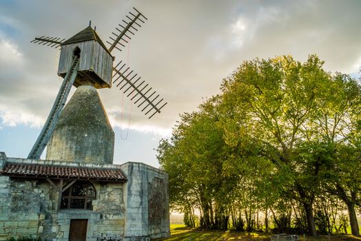 Windwill in France backlit at sunset