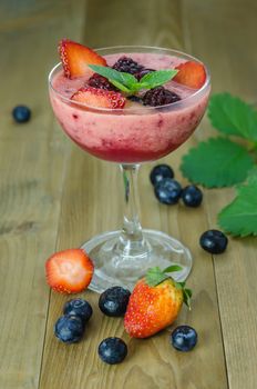 Raspberry smoothie with fresh berries on a wooden table