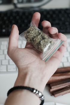 Green dry marijuana in man hand on the blurry background. Weed concept.