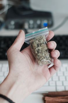 Green dry marijuana in man hand on the blurry background. Weed concept.