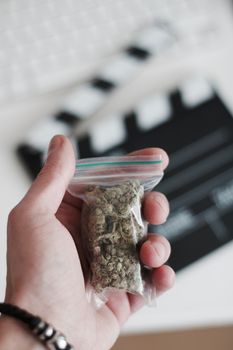 Green dry marijuana in man hand on the blurry background. Weed concept.