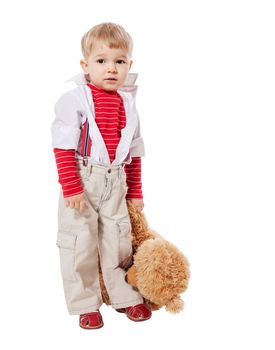 Little blond boy hugging bear toy standing isolated on white