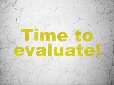 Time concept: Yellow Time to Evaluate! on textured concrete wall background