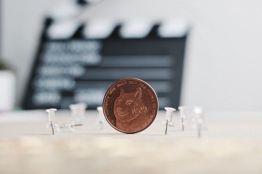 Digital currency physical brass dogecoin coin. Cinema concept.