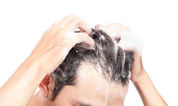 Closeup young man washing hair with white background, health care concept