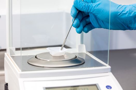 Scientist using an analytical balance at laboratory