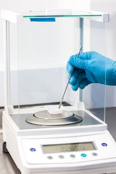 Scientist using an analytical balance at laboratory