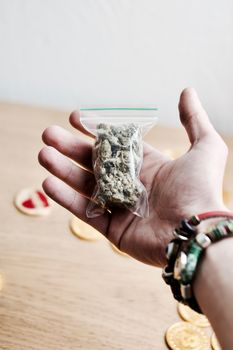 Green dry marijuana in man hand on the blurry background. Weed concept.