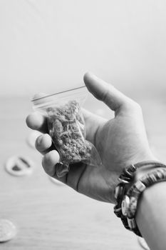Green dry marijuana in man hand on the blurry background. Weed concept.