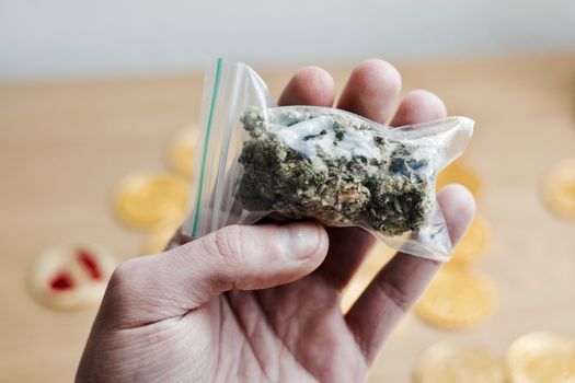 Green dry marijuana in man hand on the blurry background. Weed concept.