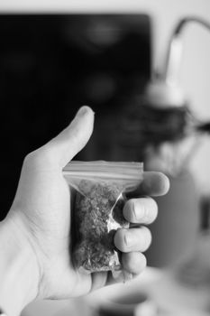 Green dry marijuana in man hand on the blurry background. Weed concept.