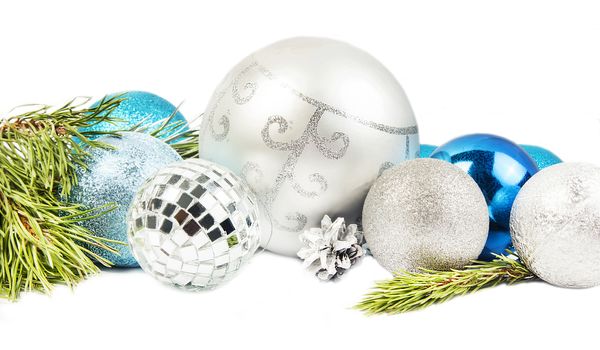 New year and Christmas composition with fir tree branch, beautiful silver ball and blue balls  on white background
