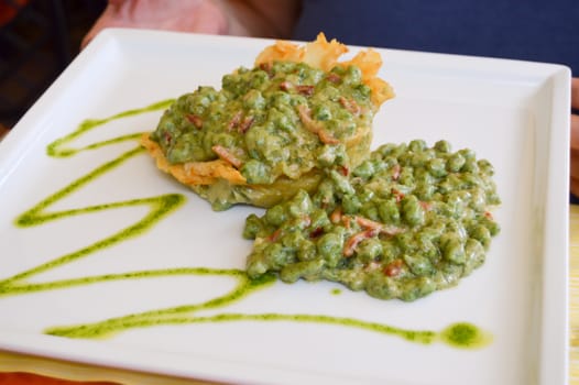 Plate of gnocchi with pesto served on a sheet of dough in dolomites in Italy