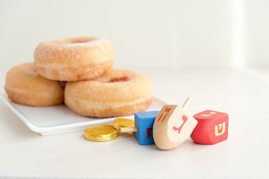 The Symbols of Hanukkah - sufganiyot, chocolate coins and sevivon