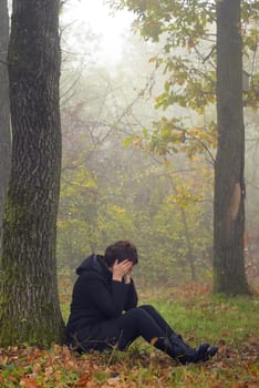 woman in depression in foggy forest
